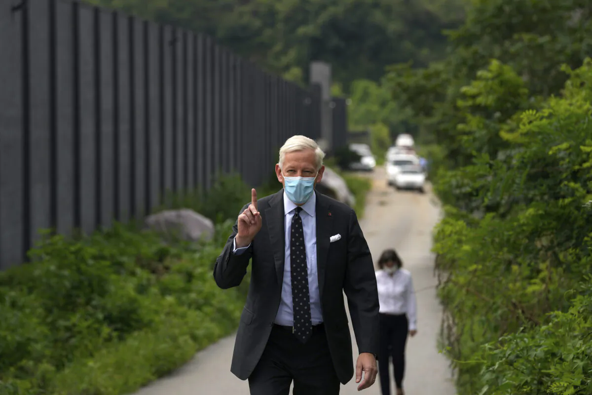 Dominic Barton, Canada Ambassador to China, wearing a face mask gestures after meeting with Canadian Michael Spavor at a detention center in Dandong, China, Aug. 11, 2021. A Chinese court has sentenced Spavor to 11 years on spying charges in case linked to Huawei. (AP Photo/Ng Han Guan)