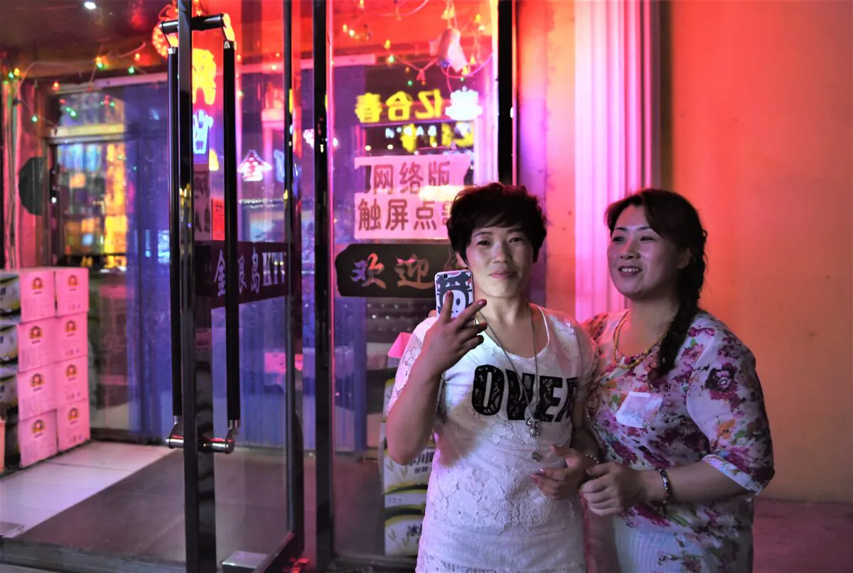 Two women outside a karaoke bar in Hunchun, in China's northeast Jilin province, on June 24, 2015. (Greg Baker/AFP via Getty Images)