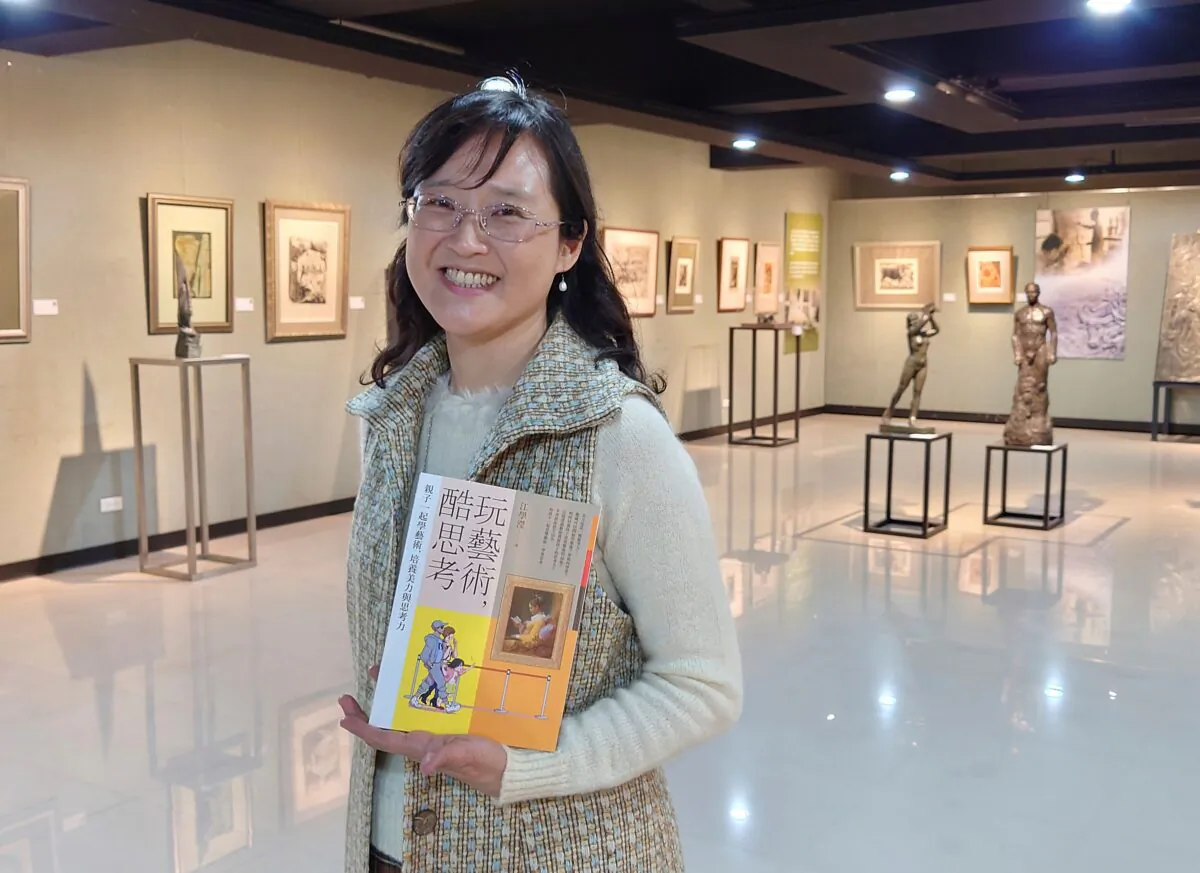 Taiwanese author Iris Chiang holds her book "Play with Art" at the saloon featuring Taiwanese artist YUYU Yang's work in Taipei, Taiwan, on March 23, 2021. (Chiang Ying-ying/AP Photo)