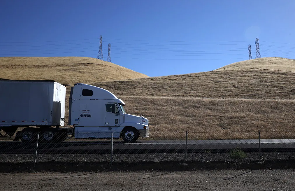 A truck drives by hills covered in dry grass along Highway 5 in Los Banos, Calif. on May 25, 2021. (Justin Sullivan/Getty Images)