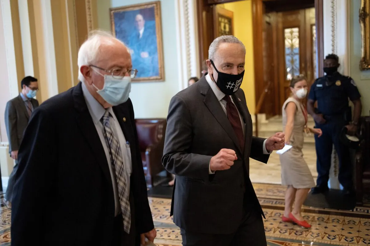 Sen. Bernie Sanders (L) (I-Vt.) walks with Senate Majority Leader Chuck Schumer (D-N.Y.) after meeting on a $3.5 trillion budged in Washington on Aug. 9, 2021. (Win McNamee/Getty Images)