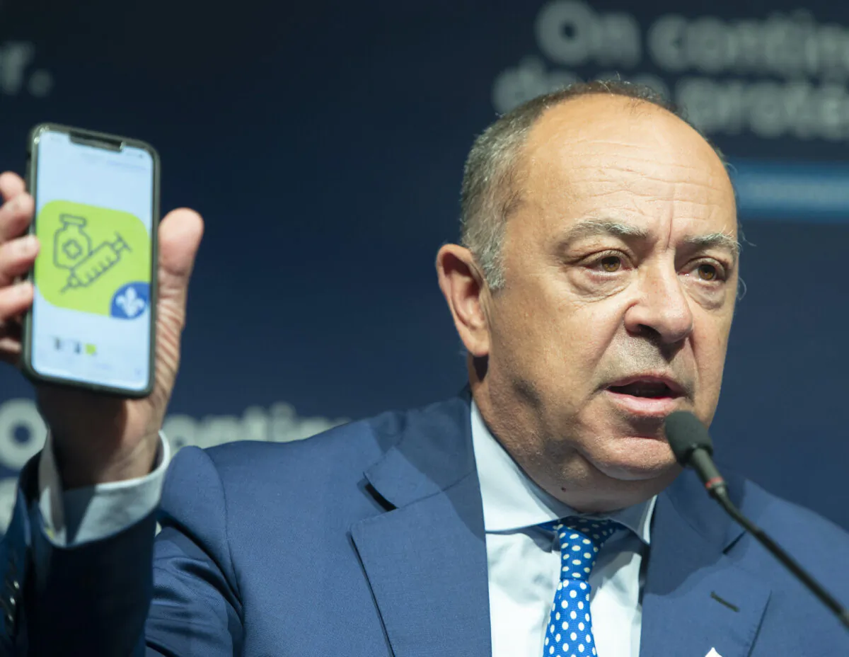Quebec Health Minister Christian Dube shows an app on his phone as he announces details of the COVID-19 vaccination passport during a news conference Tuesday, August 10, 2021 in Montreal.THE CANADIAN PRESS/Ryan Remiorz