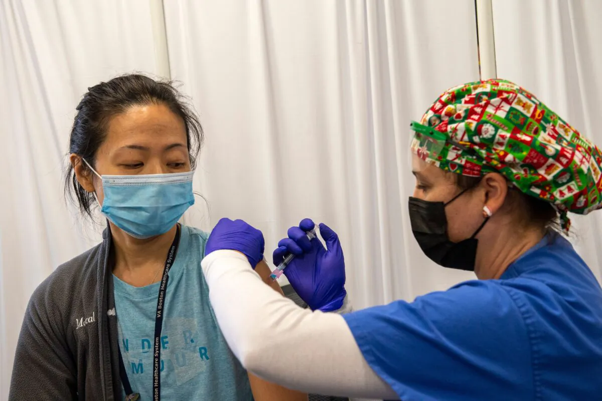 Nurse and Army veteran Renee Langone administers a Moderna COVID-19 vaccine to US Air Force (active duty reservist) Doctor Pei-Chun McGregor at the West Roxbury VA Medical Center in Boston, Mass. on Dec. 23, 2020. (Joseph Prezioso/AFP via Getty Images)