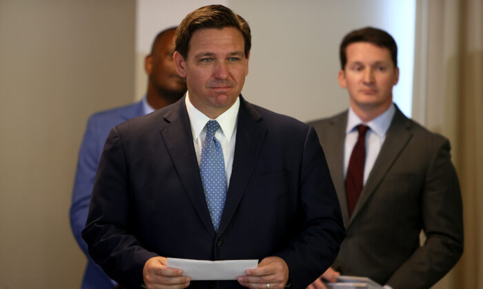 Florida Gov. Ron DeSantis waits to present a check to a first responder during an event to give out bonuses to them held at the Grand Beach Hotel Surfside in Surfside, Florida, on Aug. 10, 2021. DeSantis gave out some of the $1,000 checks that the Florida state budget passed for both first responders and teachers across the state. (Joe Raedle/Getty Images)