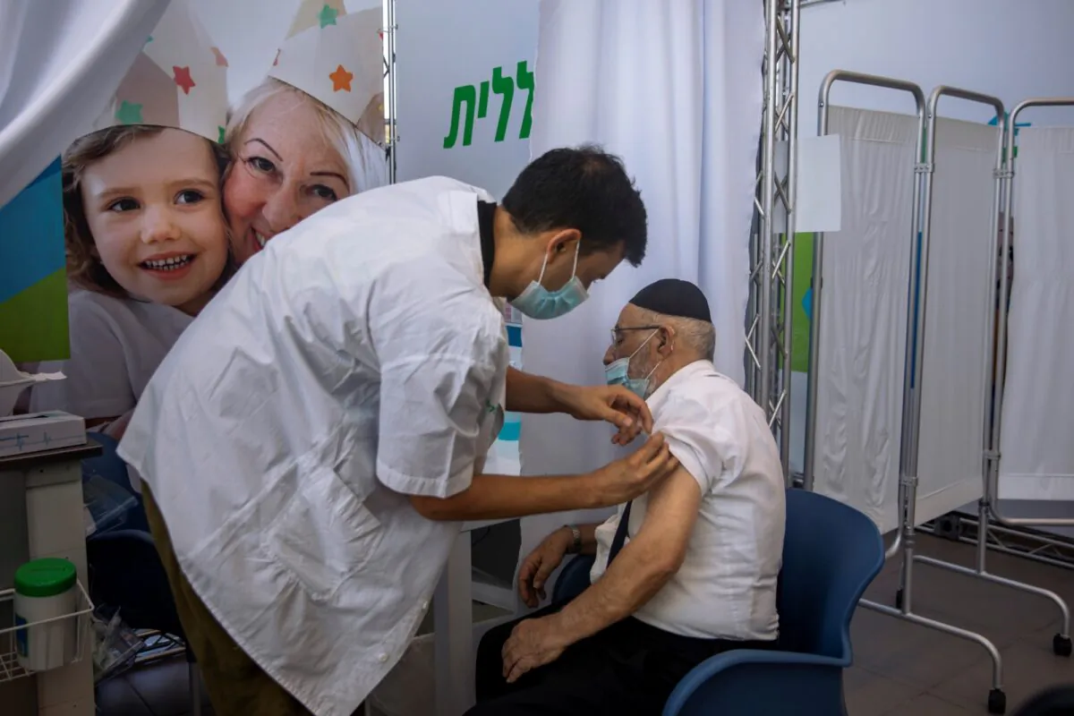 A man receives a third Pfizer-BioNTech COVID-19 vaccine from medical staff at a coronavirus vaccination center in Tel Aviv, Israel, on Aug. 10, 2021. (Oded Balilty/AP Photo)