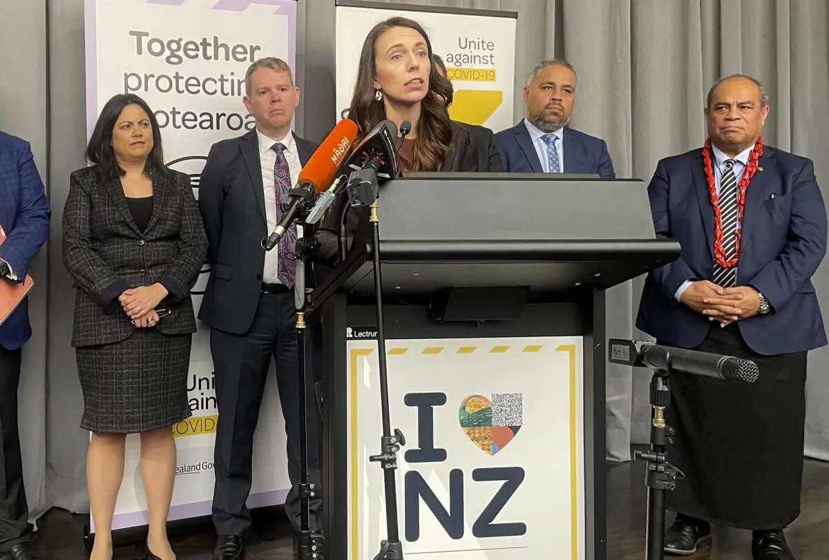 Flanked by lawmakers, New Zealand Prime Minister Jacinda Ardern delivers a speech in Wellington, New Zealand, on Aug. 12, 2021. (Nick Perry/AP Photo)
