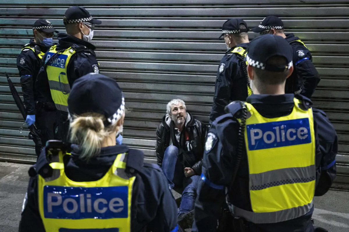 A man is detained and questioned by Police during a proposed anti-lockdown protest in Melbourne, Australia, on Aug. 11, 2021. (AAP Image/Daniel Pockett) 