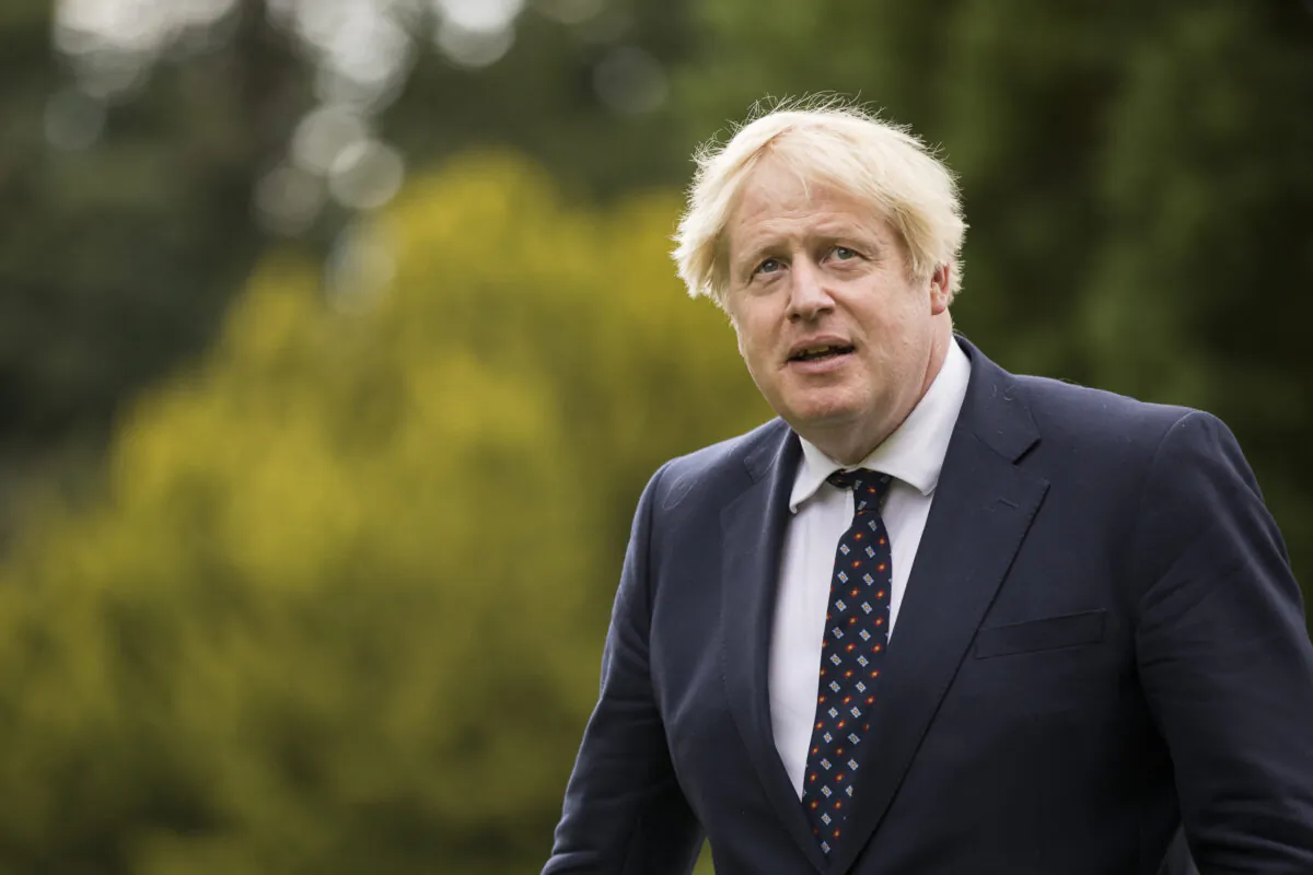 Britain's Prime Minister Boris Johnson gestures as he meets police officers near Kincardine, Scotland on Aug. 4, 2021. (James Glossop / POOL / AFP via Getty Images)