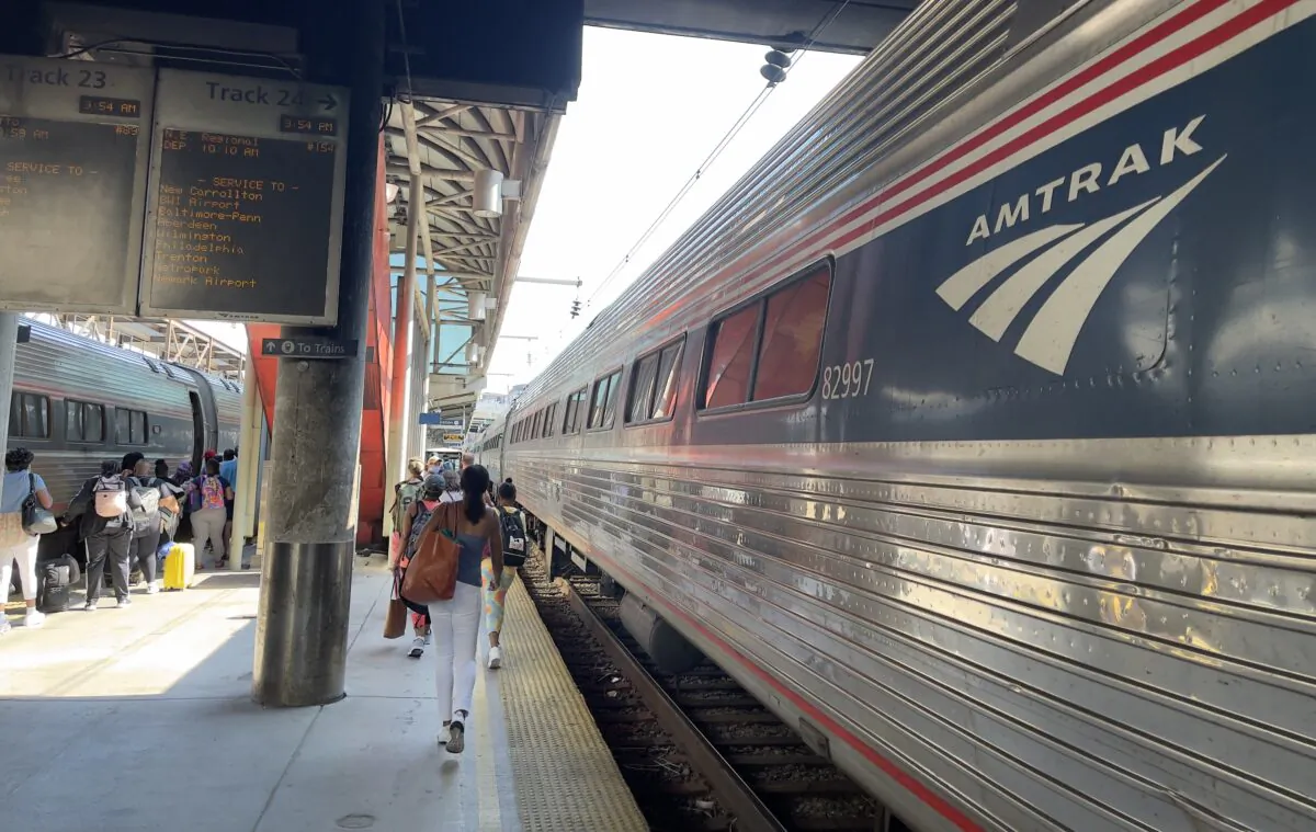 Passengers walk along an Amtrak train on a track at Union station in Washington on July 18, 2021. (Daniel Slim/AFP via Getty Images)