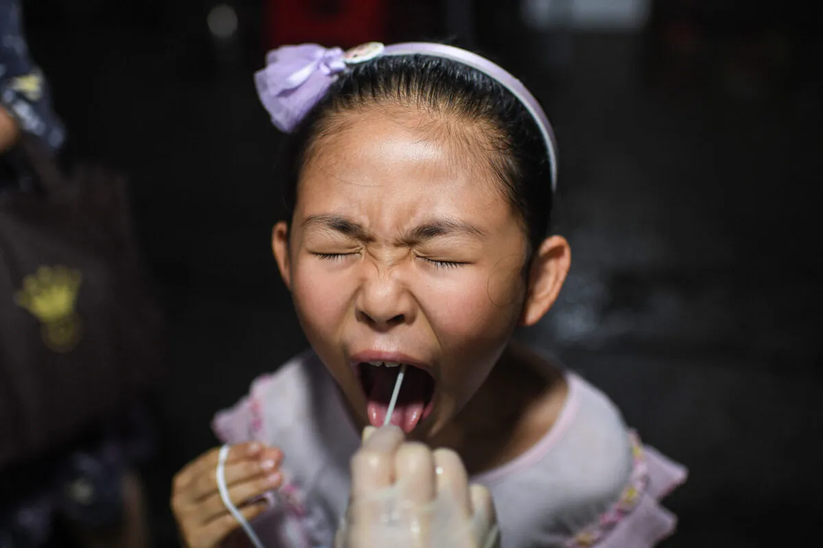 A child receives a COVID-19 test at a residential area in Wuhan, Hubei Province on Aug. 11, 2021. (STR/AFP via Getty Images)
