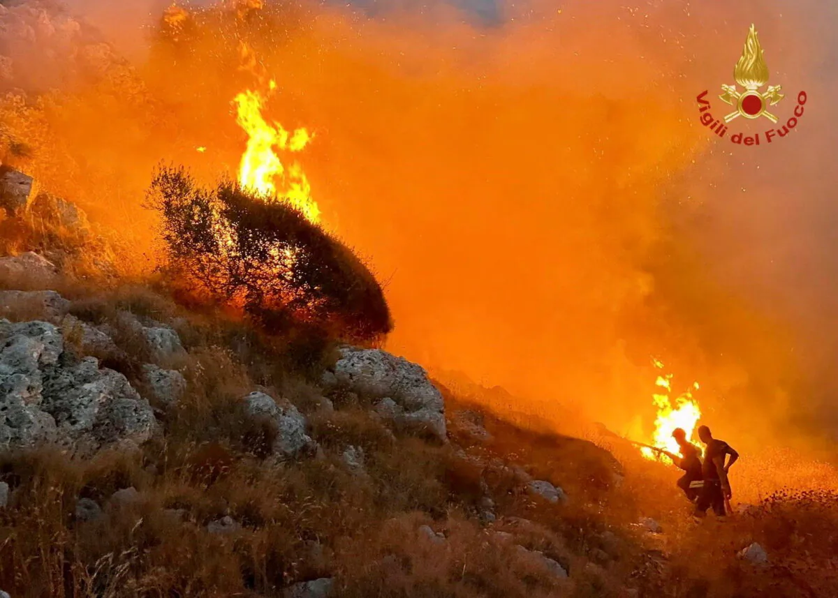 Firefighters battle wildfires in the beach village of Porto Badisco near Otranto in the southern region of Puglia, Italy, on Aug. 13, 2021. (Vigili del Fuoco/Handout via Reuters)