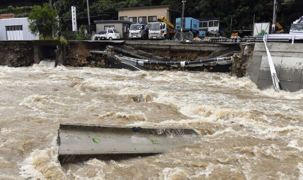 A road is damaged by the swollen Suzuhari river caused by a heavy rain in Hiroshima, western Japan, on Aug. 13, 2021. (Kyodo/via Reuters)