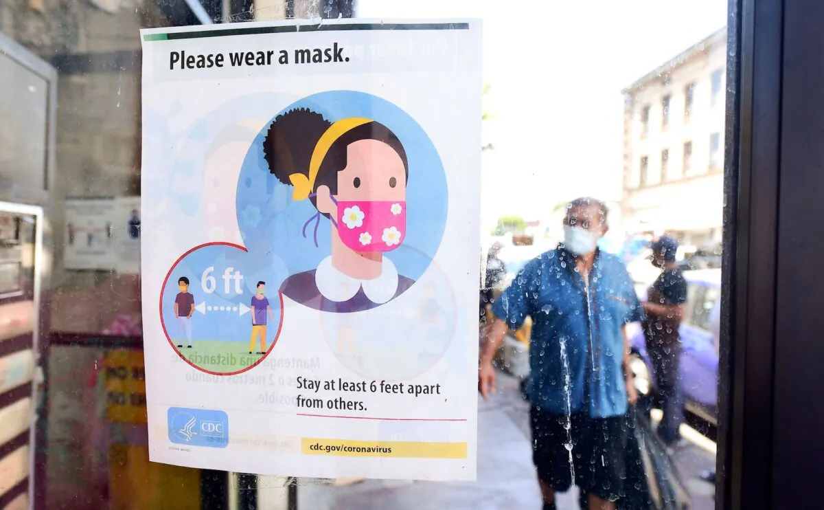 A storefront sign reminds people to wear a facemask in Los Angeles, California, on July 19, 2021. (Frederick J.Brown /AFP via Getty Images)