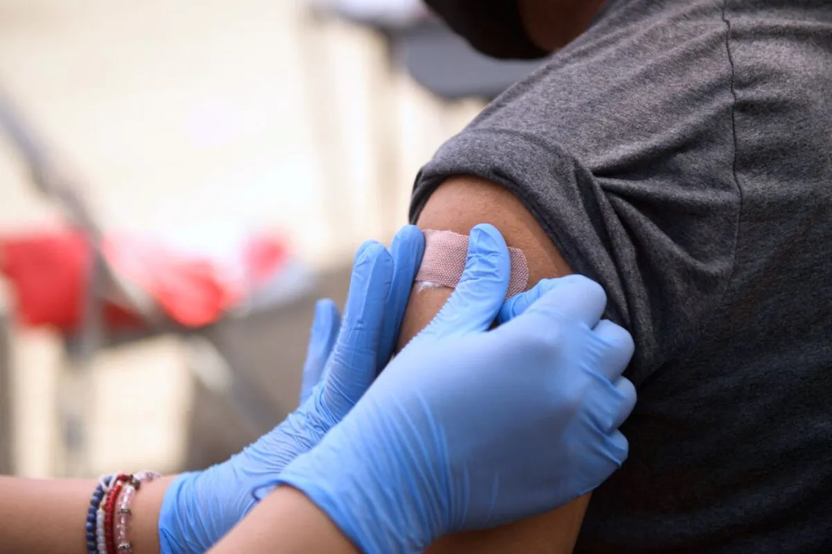 A person receives a bandage after their first dose of a COVID-19 vaccine at a mobile vaccination clinic at the Weingart East Los Angeles YMCA in Los Angeles on Aug. 7, 2021. (Patrick T. Fallon/AFP via Getty Images)