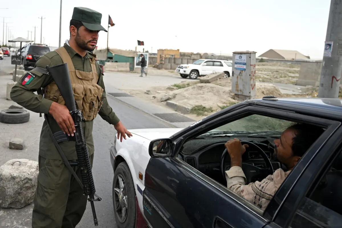 An Afghan policeman speaks to a commuter in car at a checkpoint along the road in Kabul, Afghanistan on Aug. 14, 2021. (Wakil Kohsar/AFP via Getty Images)