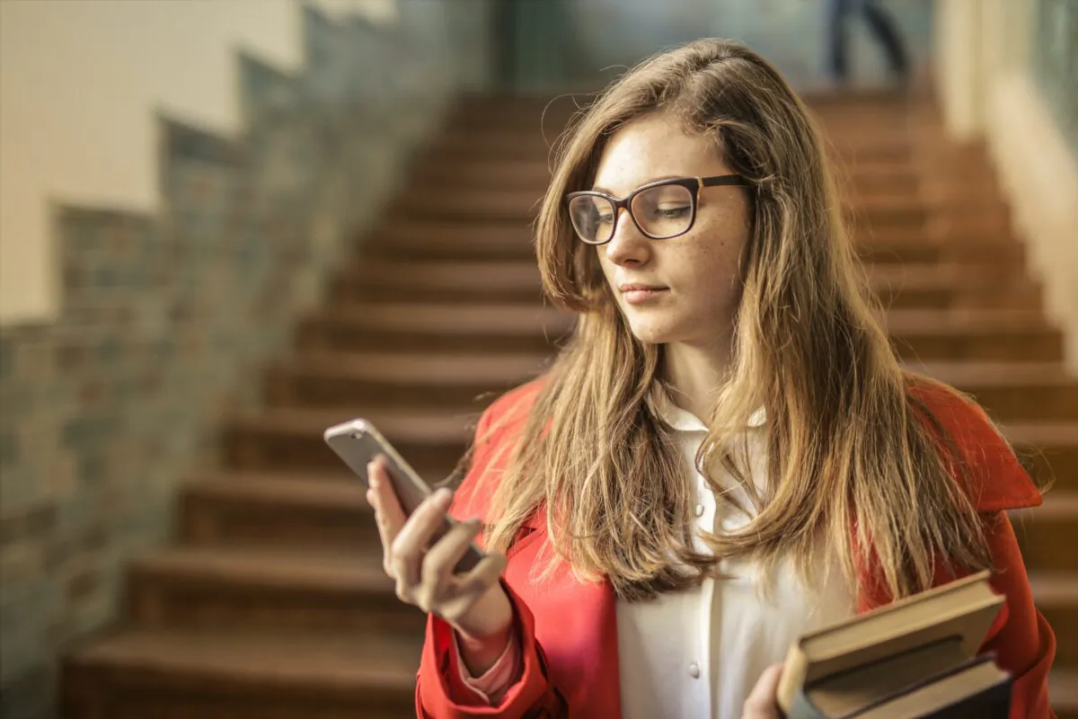 A woman looks at her phone. (Andrea Piacquadio/Pexels)
