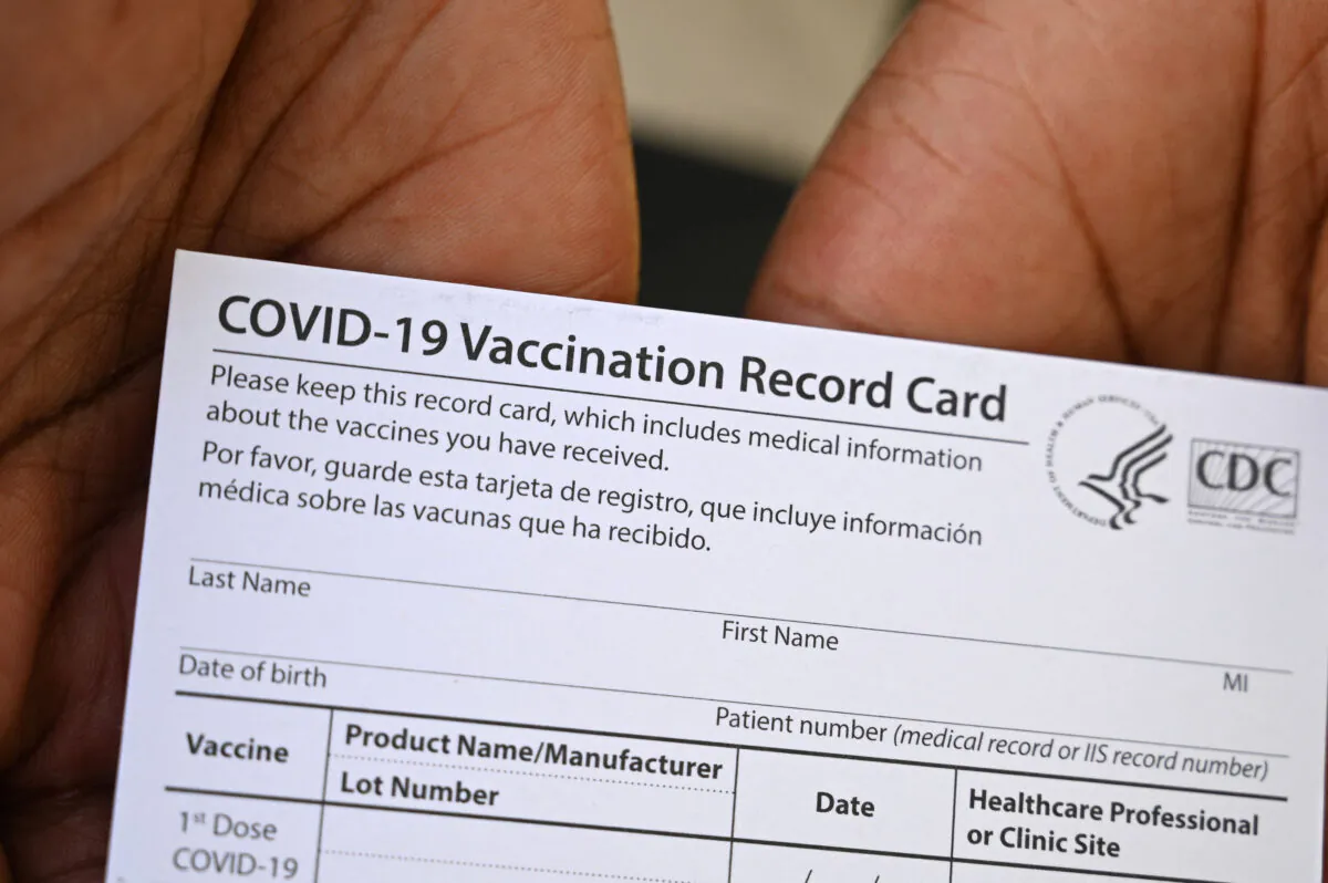 A healthcare worker displays a COVID-19 Vaccination Record Card during a vaccine and health clinic at QueensCare Health Center in a predominantly Latino neighborhood in Los Angeles, Calif., on Aug. 11, 2021. (Robyn Beck/AFP via Getty Images)