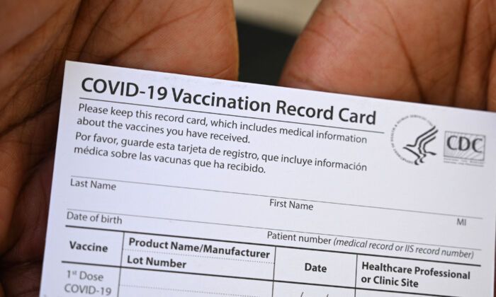 A health care worker displays a COVID-19 Vaccination Record Card during a vaccine and health clinic at QueensCare Health Center in a predominantly Latino neighborhood in Los Angeles, Calif., on Aug. 11, 2021. (Robyn Beck/AFP via Getty Images)