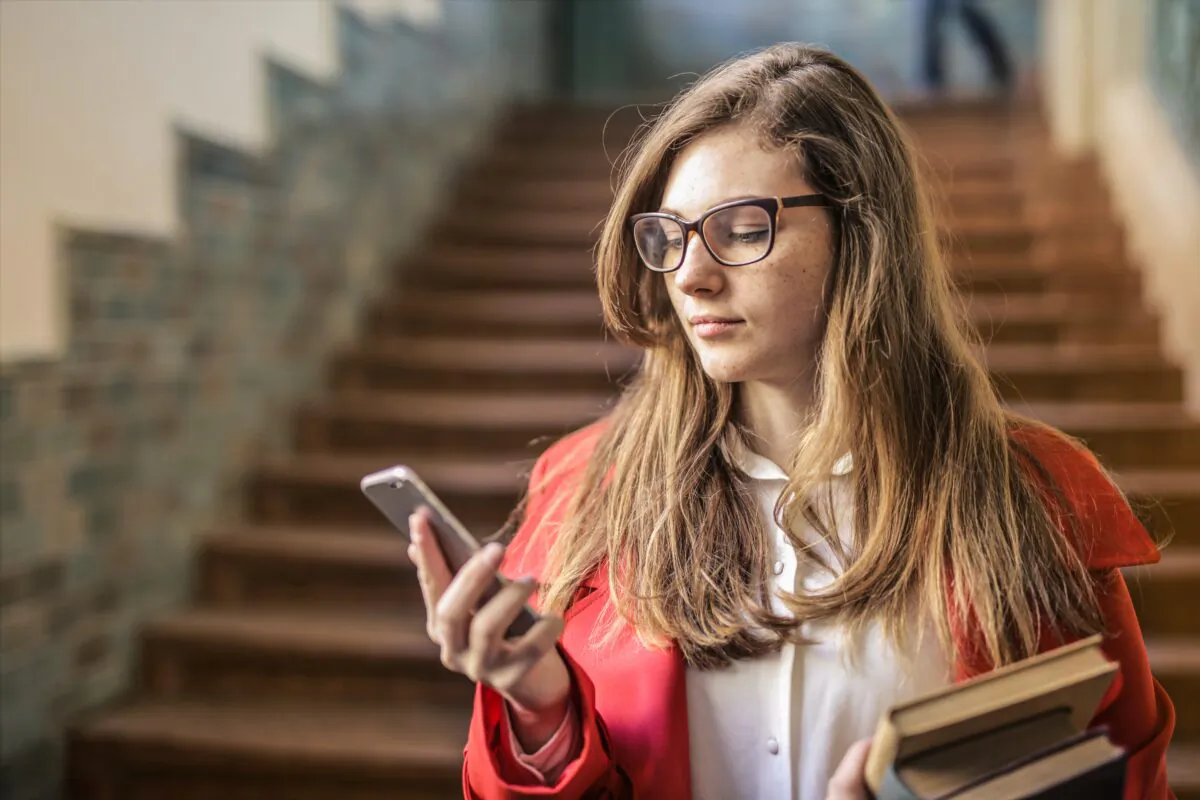 A woman looks at her phone. (Andrea Piacquadio/Pexels)