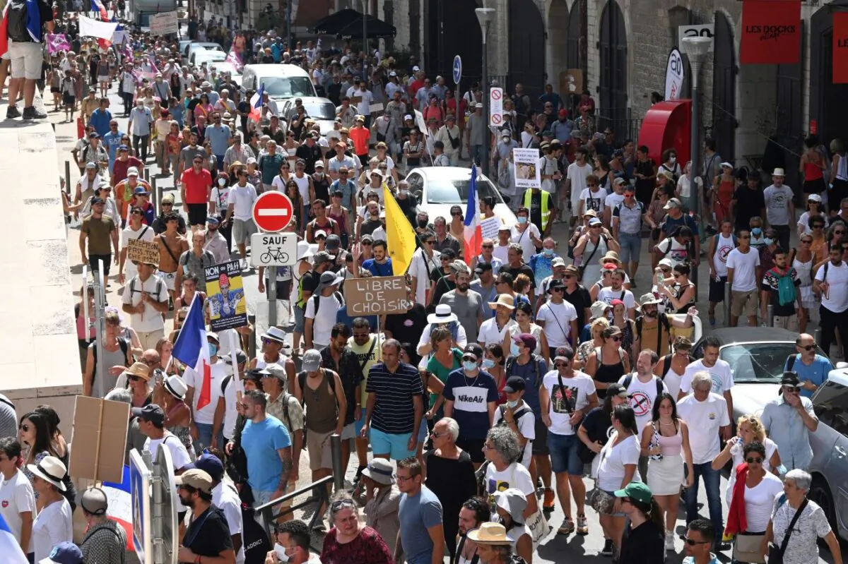 Demonstrators march during a national day of protest against the compulsory COVID-19 vaccination for certain workers and vaccine passports. (Sylvian Thomas/AFP via Getty Images)