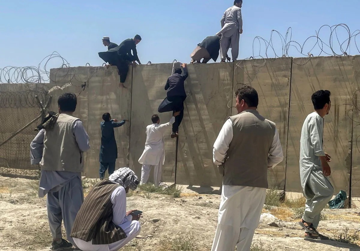 Men try to get inside Hamid Karzai International Airport in Kabul, Afghanistan, on Aug. 16, 2021. (Stringer/Reuters)