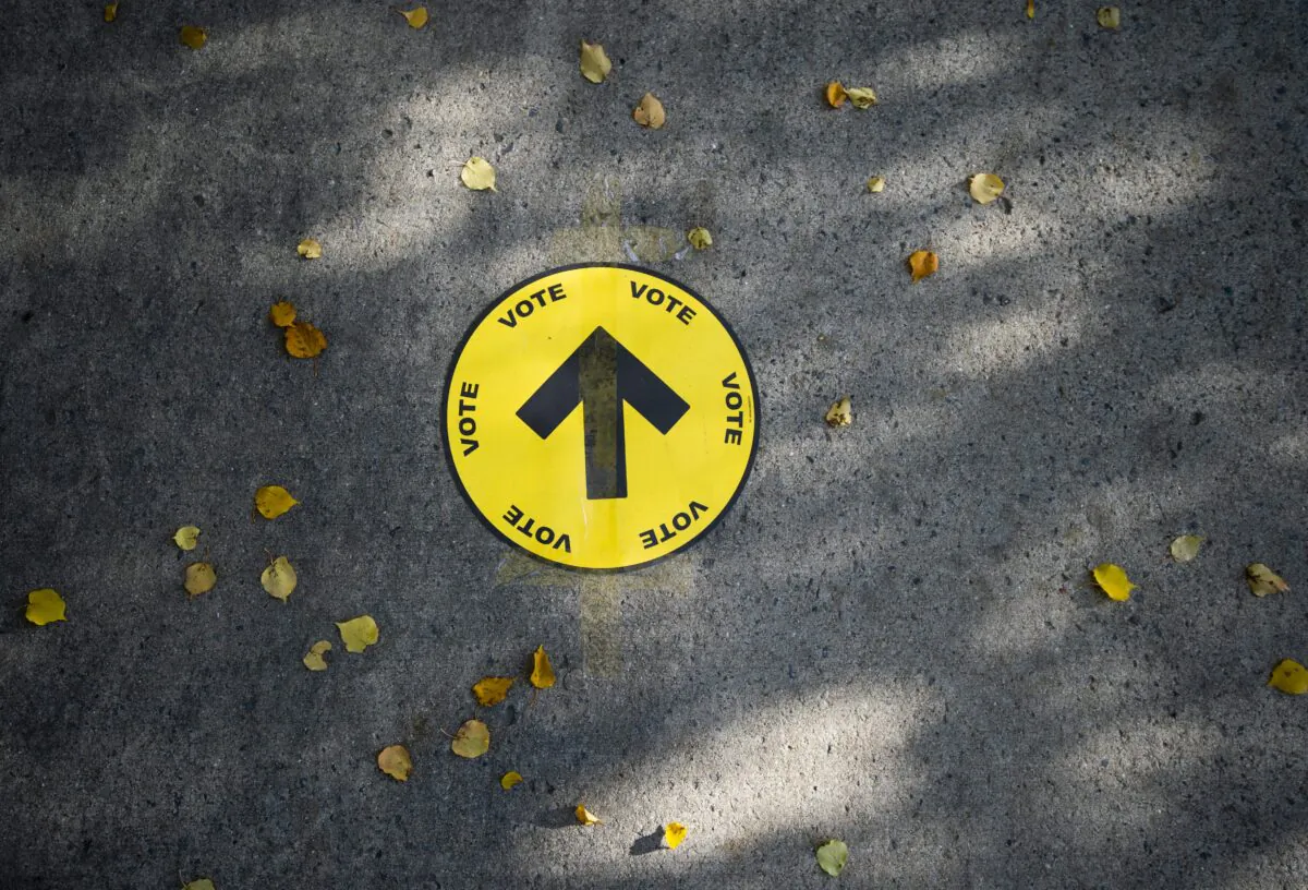 A sign directing voters to a polling station is taped to the sidewalk during the 2019 federal election, in Ottawa on Oct. 21, 2019.  (The Canadian Press/Justin Tang)