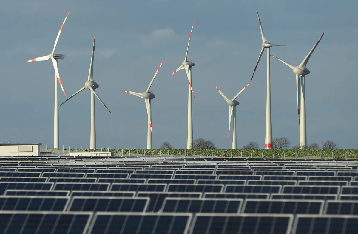 Wind turbines stand behind a solar power park near Werder, Germany on Oct. 30, 2013. (Sean Gallup/Getty Images)