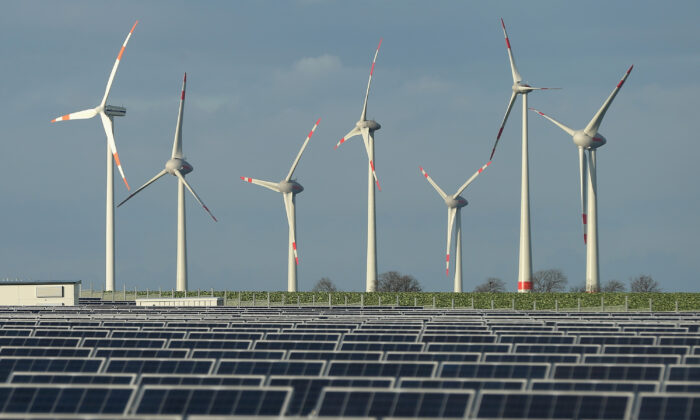 Wind turbines stand behind a solar power park near Werder, Germany on Oct. 30, 2013. (Sean Gallup/Getty Images)