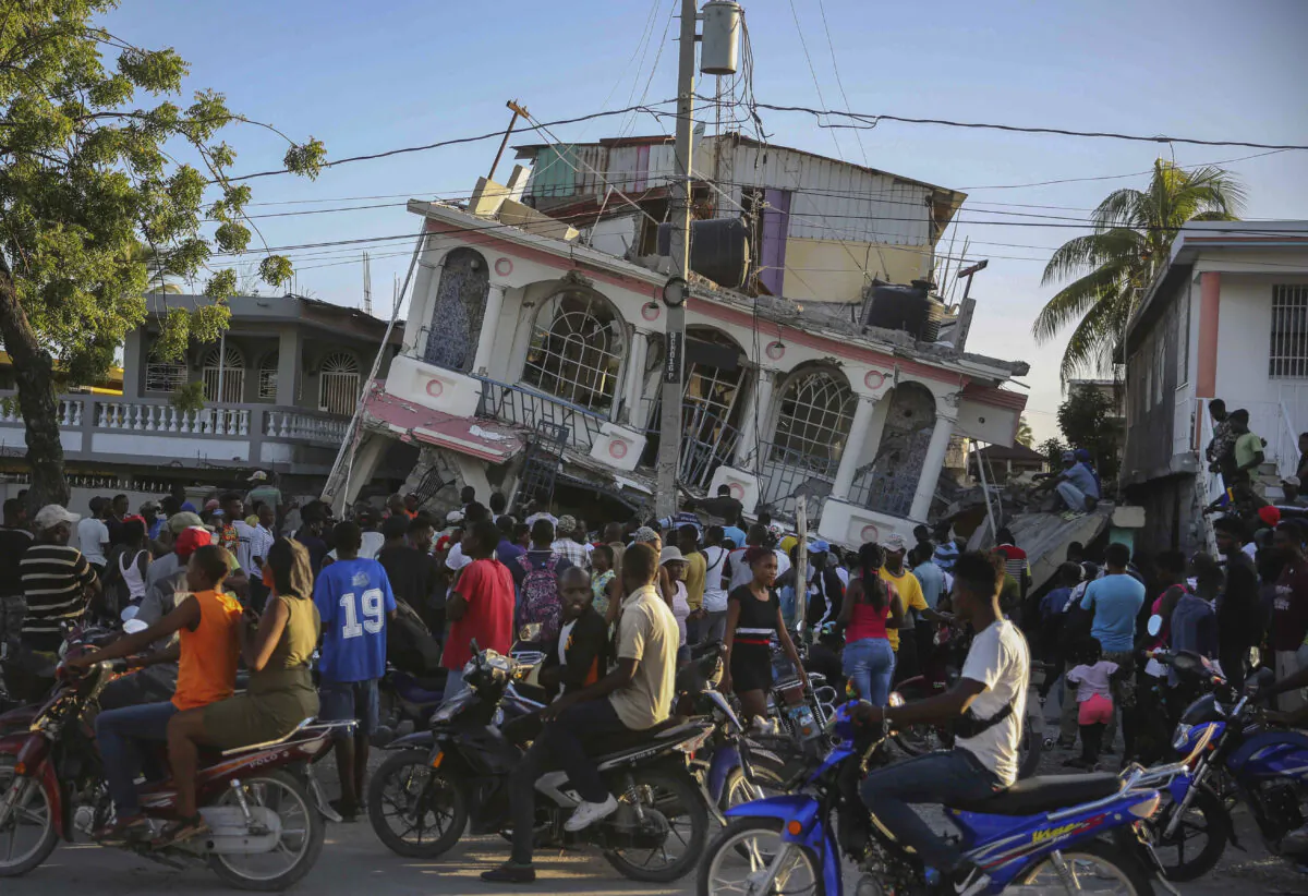 People gather outside the Petit Pas Hotel, destroyed by the earthquake in Les Cayes, Haiti on Aug. 14, 2021. (Joseph Odelyn/AP Photo)