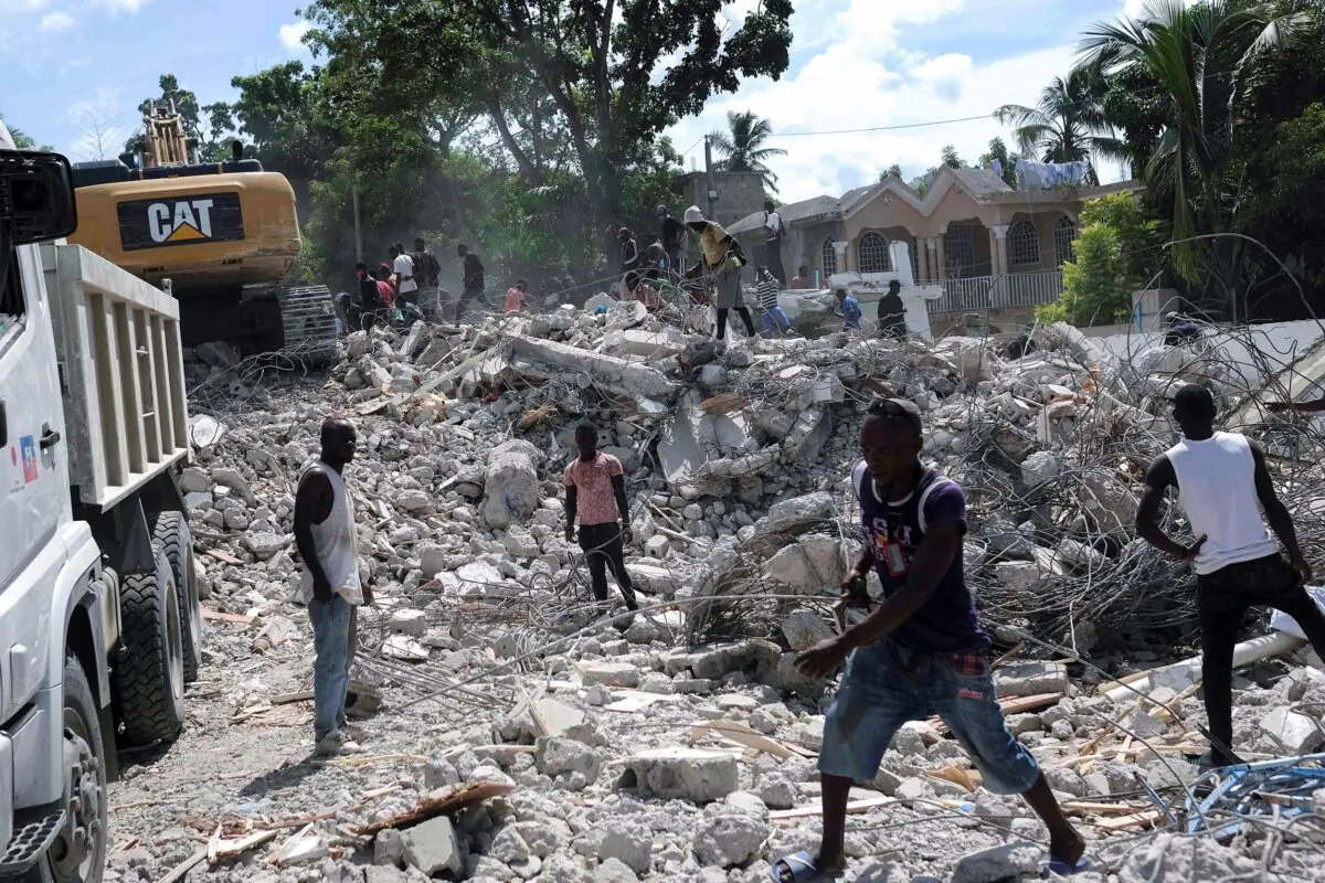 People remove debris at the collapsed Le Manguier hotel in Les Cayes, Haiti, on Aug. 16, 2021. (Matias Delacroix/AP Photo)