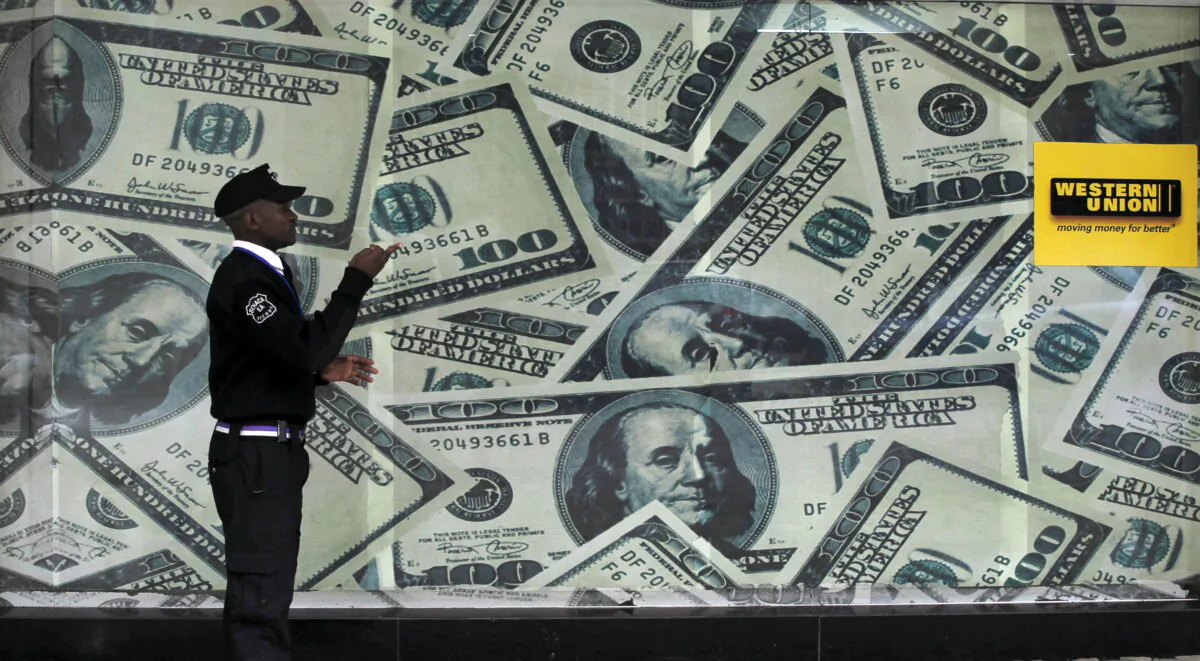 A security guard walks past a montage of old U.S. dollar bills outside a currency exchange in Nairobi, Kenya, on July 23, 2015. (Thomas Mukoya/Reuters)