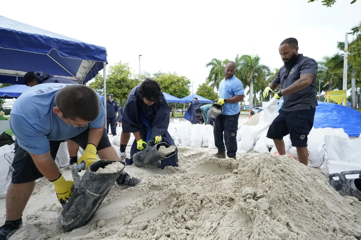 City workers fill sandbags at a drive-thru sandbag distribution event for residents ahead of the arrival of rains associated with Tropical Storm Fred, at Grapeland Park in Miami, Fla., on Aug. 13, 2021. (Wilfredo Lee/AP Photo)