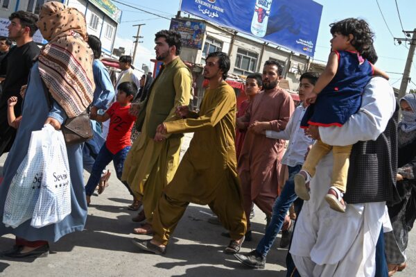 Afghan people run toward the Kabul airport to leave Kabul on Aug. 16, 2021. (Wakil Kohsar/AFP via Getty Images)