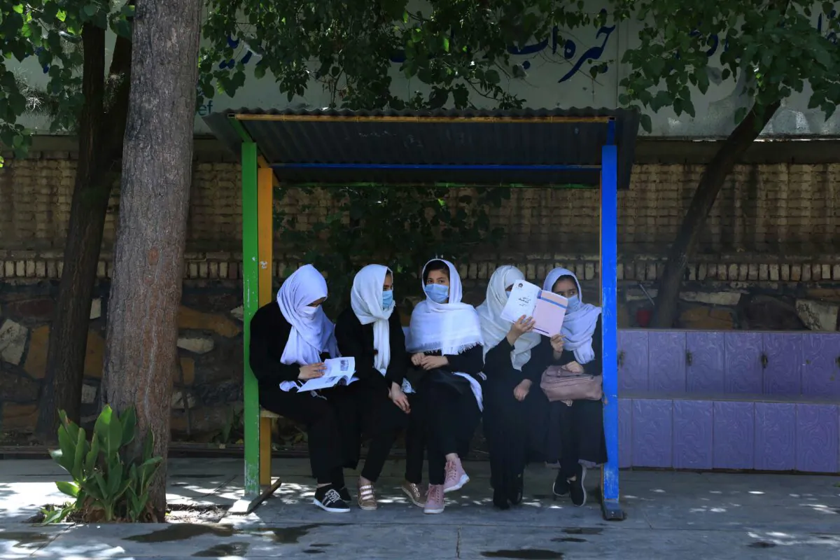 Schoolgirls sit at the schoolyard in Herat on Aug. 17, 2021, following the Taliban takeover of the country. (Aref Karimi/AFP via Getty Images)