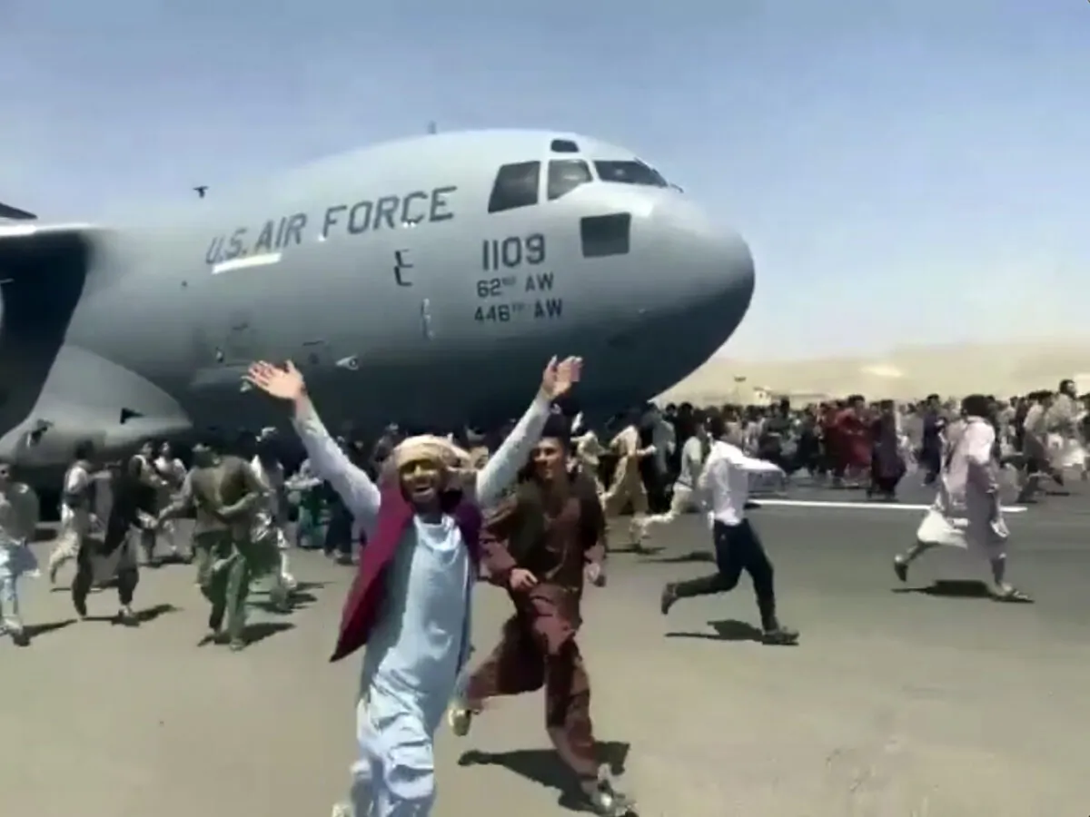Hundreds of people run alongside a U.S. Air Force C-17 transport plane as it moves down a runway of the international airport, in Kabul, Afghanistan, on Aug. 16. 2021. (Verified UGC via AP)