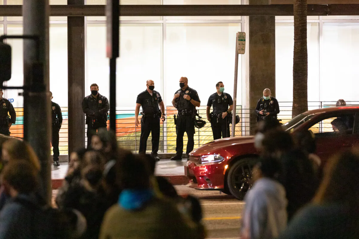 Los Angeles Police Officers assembled across the street as protestors gather in front of a Chase Bank building on the corner of Sunset Blvd. and Vine St., in Los Angeles, Calif., on April 16, 2021. (John Fredricks/The Epoch Times)