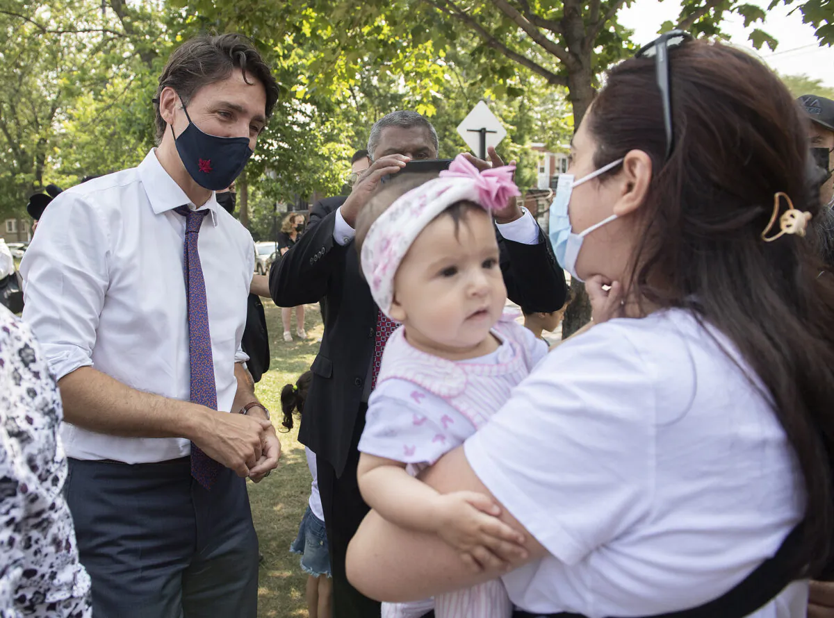 Liberal Leader Justin Trudeau talks with a family following a child-care funding announcement in Montreal on Aug. 5, 2021. (The Canadian Press/Graham Hughes)