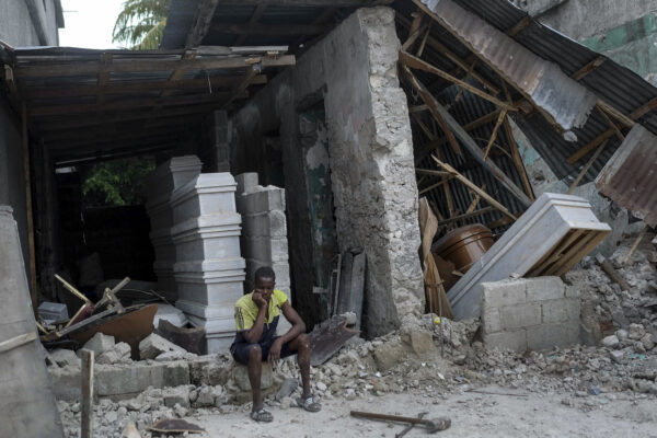 Man sits in front collapsed funeral home