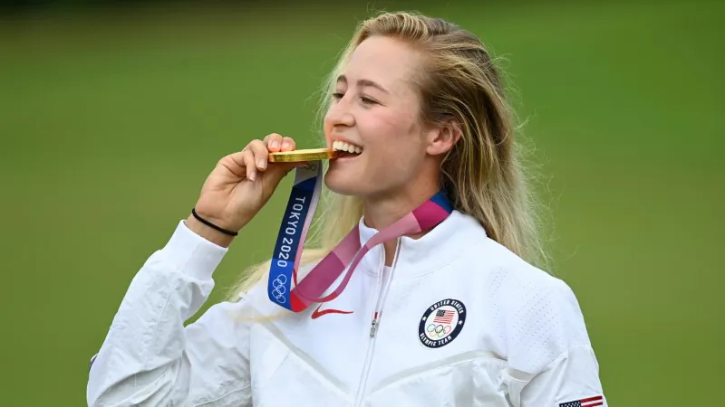 Gold medalist Nelly Korda of the United States bites her medal on the podium during the victory ceremony of the women's golf individual stroke play during the Tokyo 2020 Olympic Games at the Kasumigaseki Country Club in Kawagoe, Saitama, Japan, on Aug. 7, 2021. (Toby Melville/Reuters)