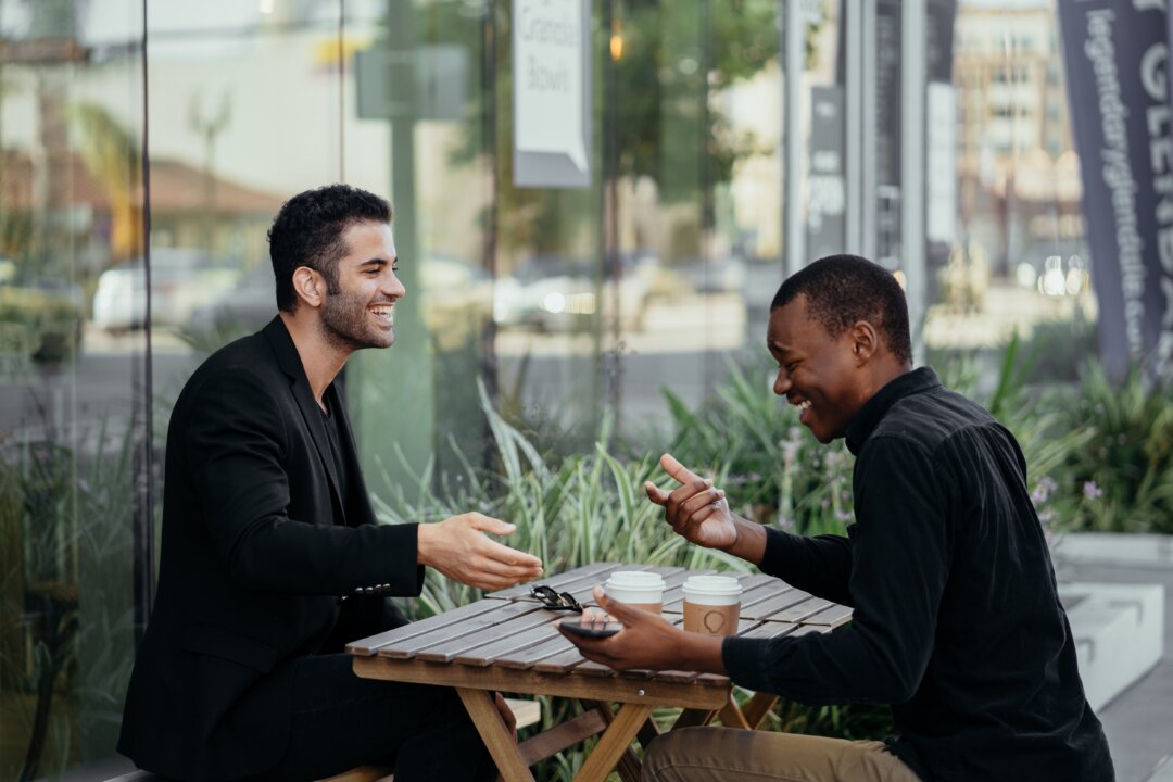 Two men having a conversation. (Pexels)