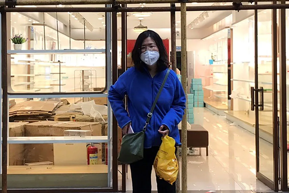 Zhang Zhan stands near scaffolding outside a shop during a visit to Wuhan in Hubei province, China, on April 11, 2020. (Courtesy of Melanie Wang via AP)