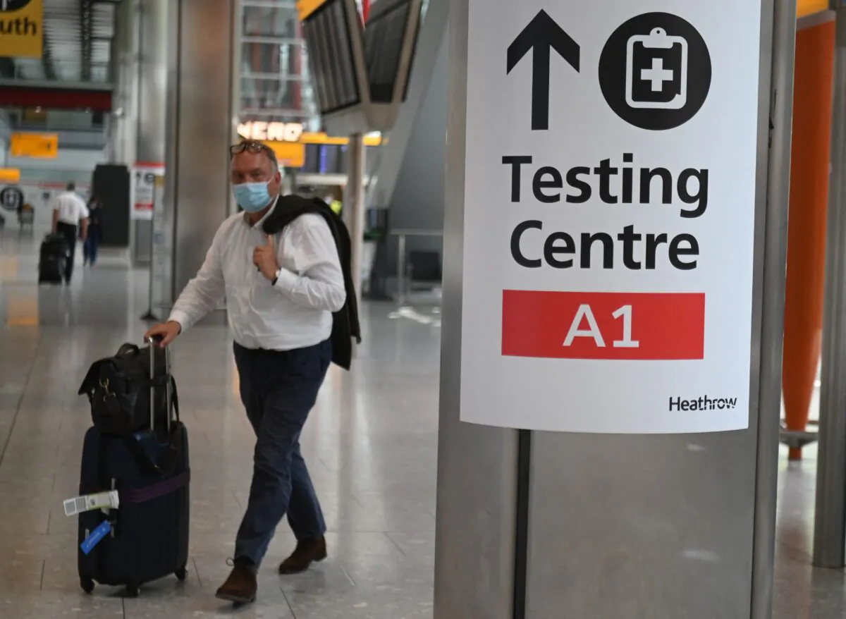 A passenger walks past signage displaying the way to a COVID-19 test centre, in Terminal 5 at Heathrow airport in London, on June 3, 2021. (Daniel Leal-Olivas/AFP via Getty Images)