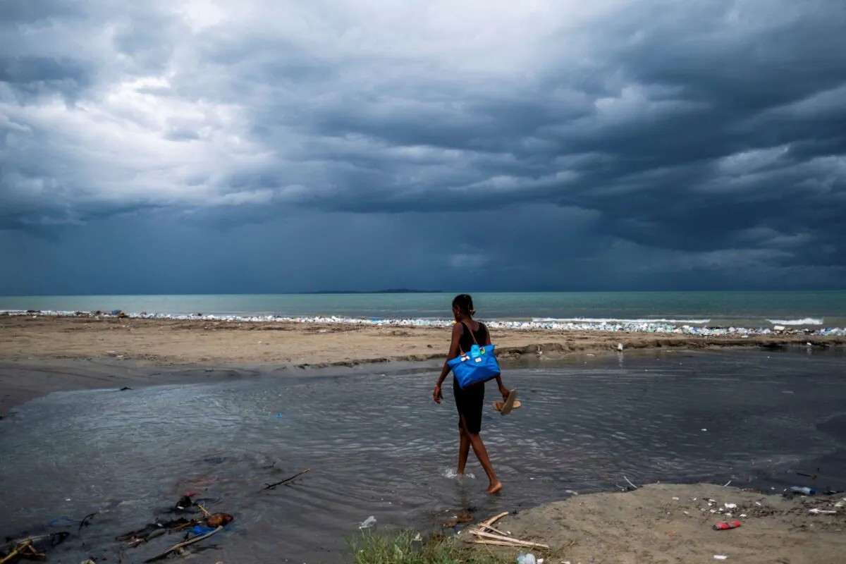 A woman wades through the water, as Tropical depression Grace approaches, after Saturday's 7.2 magnitude quake, in Les Cayes, Haiti, on Aug. 16, 2021. (Ricardo Arduengo/Reuters)