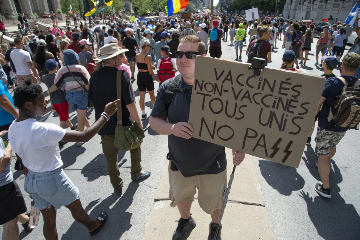 Protesters march during a demonstration against Quebec’s decision to impose a vaccination passport for non-essential businesses and services, in Montreal on Aug. 14, 2021. (The Canadian Press/Peter McCabe)