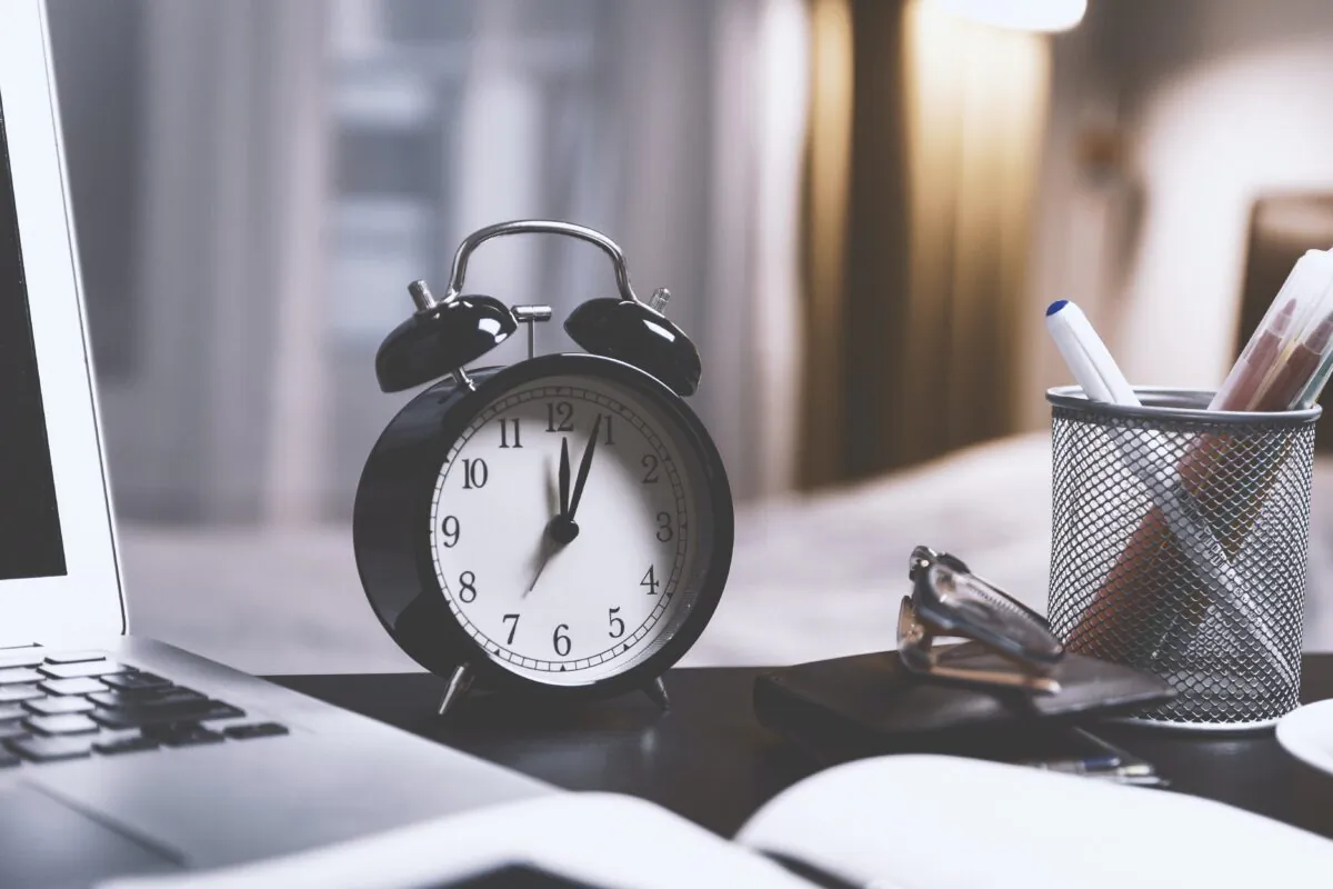 A clock on a desk. (Pexels)