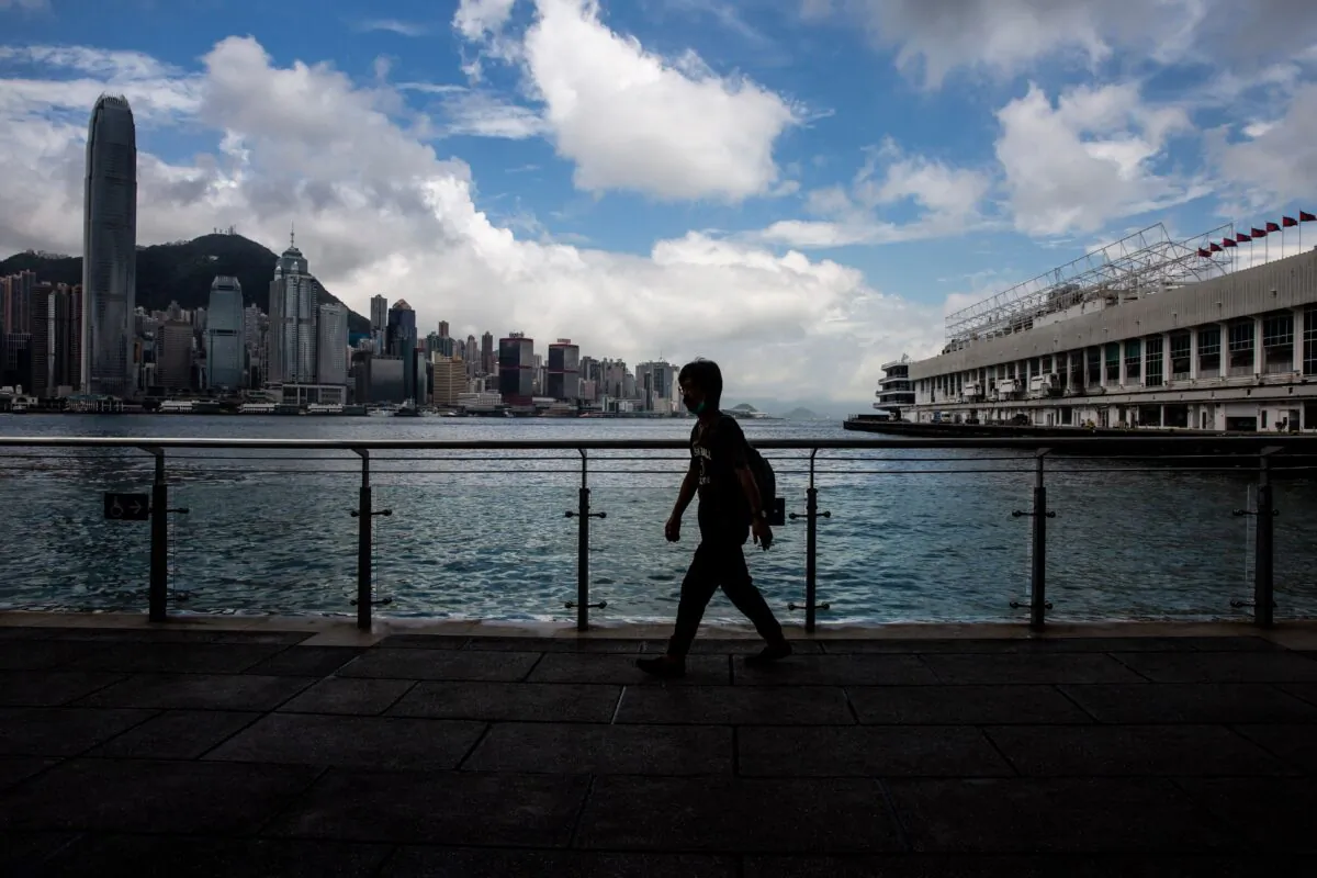 A man walks along Victoria Harbour in the Kowloon district of Hong Kong on Aug. 16, 2021. (Isaac Lawrence/AFP via Getty Images)