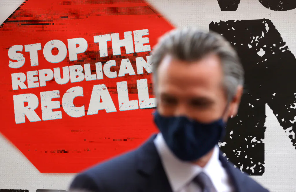 A sign against the recall is posted behind California Gov. Gavin Newsom as he talks with volunteers in San Francisco, on Aug. 13, 2021. (Justin Sullivan/Getty Images)