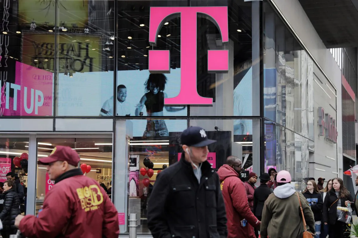 Pedestrians walk past a T-Mobile store in New York on April 27, 2018. (Lucas Jackson/Reuters)