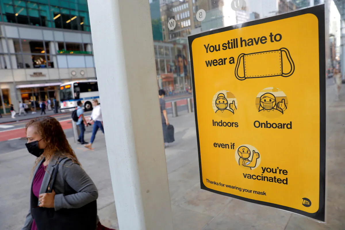 A poster alerting people to wear a mask is seen on a 42nd Street subway entrance in New York City, on Aug. 2, 2021. (Andrew Kelly/Reuters)