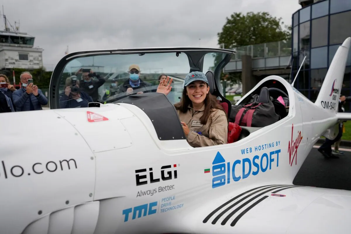 Belgian-British teenager Zara Rutherford waves from her Shark Ultralight airplane prior to take off at the Kortrijk-Wevelgem airfield in Wevelgem, Belgium, on Aug. 18, 2021. (Virginia Mayo/AP Photo)